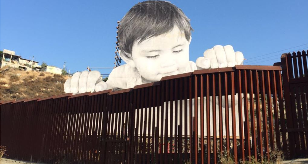 Colocan imagen gigante de niño que se asoma por muro EE.UU.-México